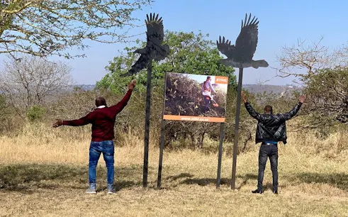 Two people with outstretched arms near bird sculptures at Natal Lion Park, Durban.