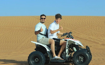 Two people riding an ATV in the desert during a morning safari.