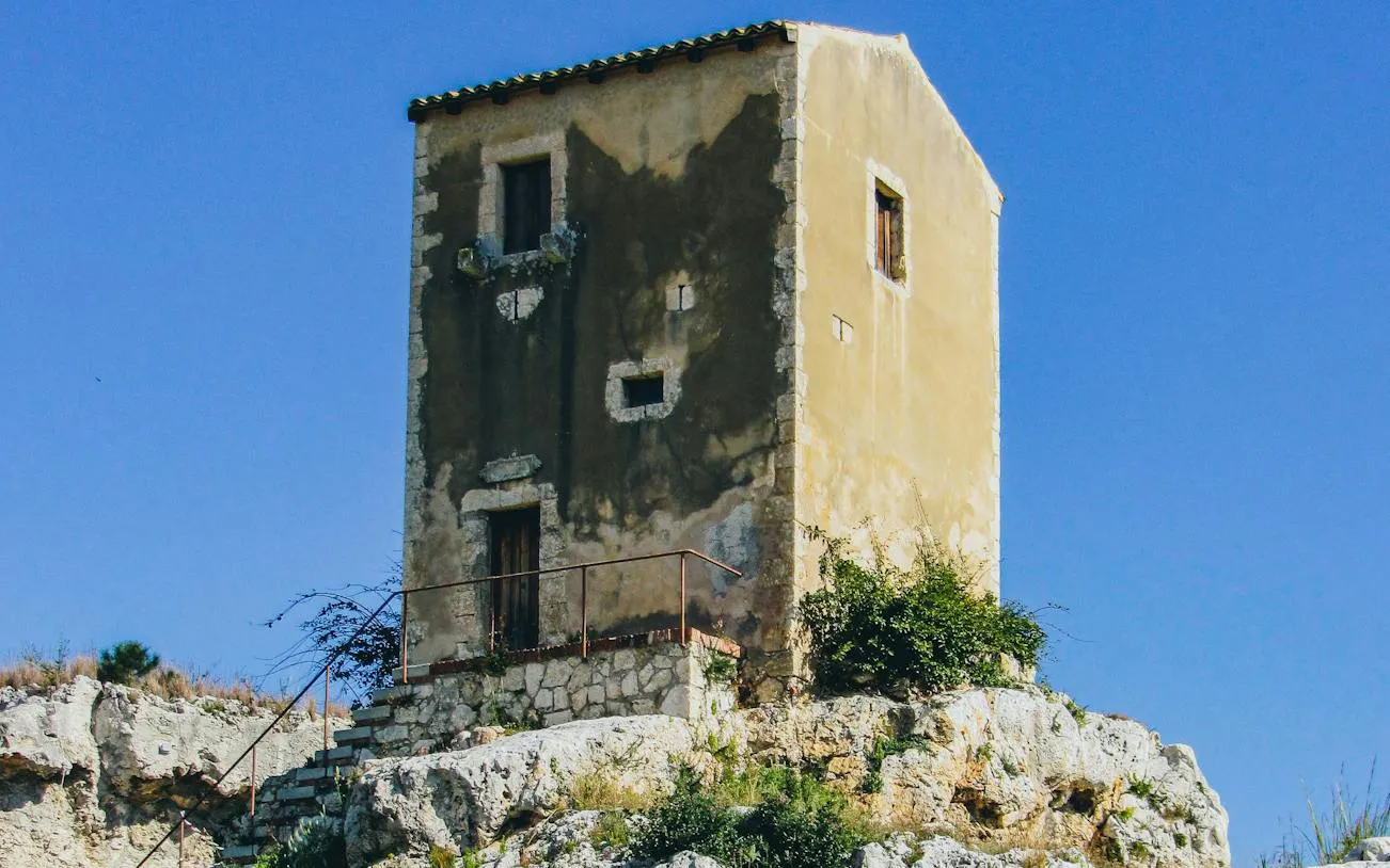 Stone building on rocky terrain at Neapolis Archaeological Park, Siracusa.