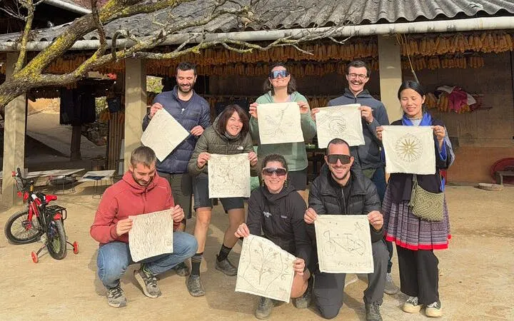 Tourists display traditional artwork during a private car tour from Sapa to Mu Cang Chai rice terraces.