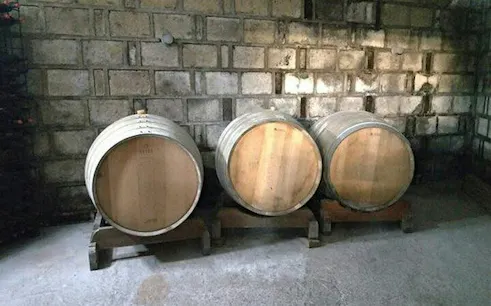 Wine barrels in a Trentino Valle dei Laghi cellar, Trento winery tour.