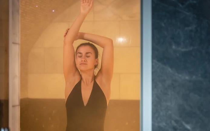 Woman enjoying steam in Moroccan hammam, Marrakesh massage experience.