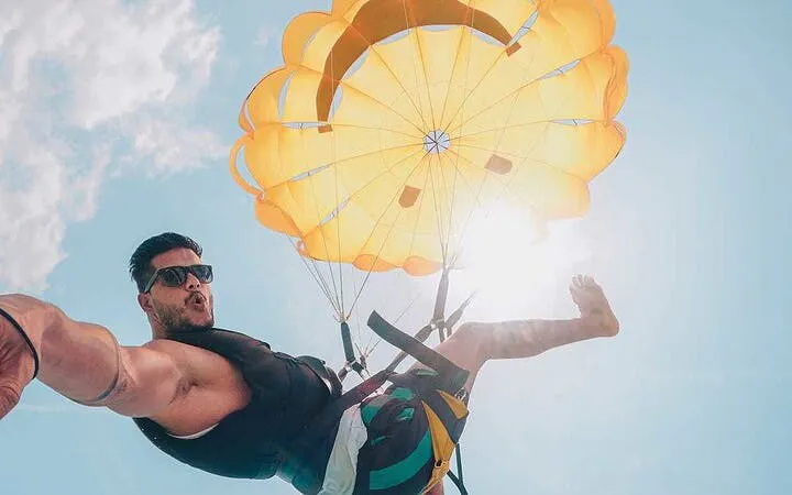 Parasailing adventure over Hurghada with a bright yellow parachute against a clear sky.