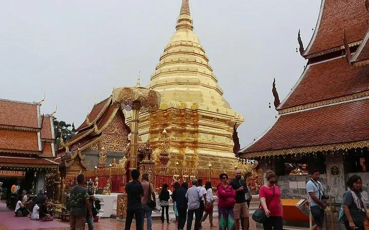 Doi Suthep Temple golden stupa with tourists exploring, Chiang Mai guided tour.