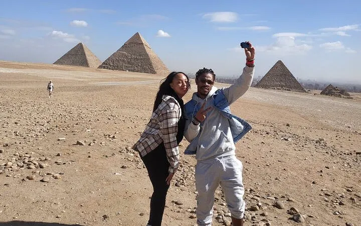 Tourists taking a selfie with the Giza Pyramids in the background, Egypt.