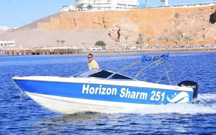 Speedboat on the water near Sharm El Sheikh cliffs, part of a private tour.