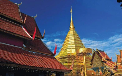 Golden stupa at Wat Phra That Doi Suthep, Chiang Mai, under a clear blue sky.