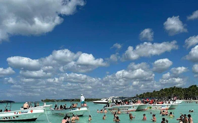 Speedboats and tourists in turquoise waters at Saona Island, Punta Cana.