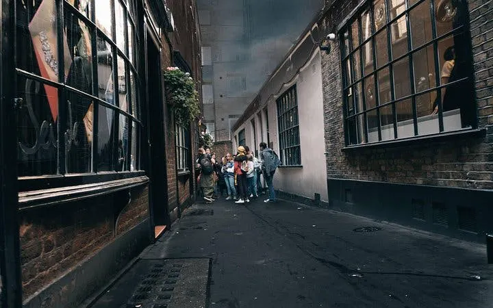 Group exploring narrow alley on Harry Potter walking tour in London.