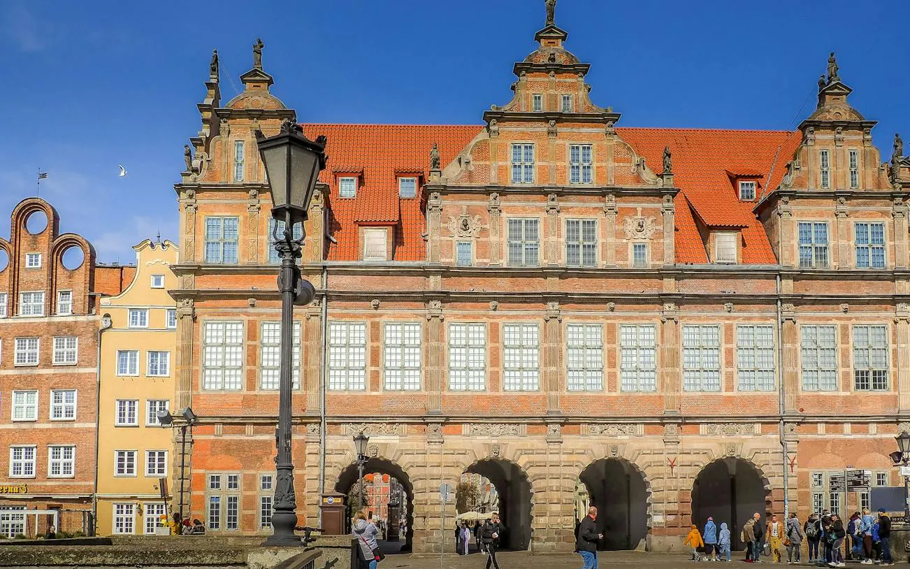 Gdansk Old Town building with red roof and arched entrances on self-guided audio tour.