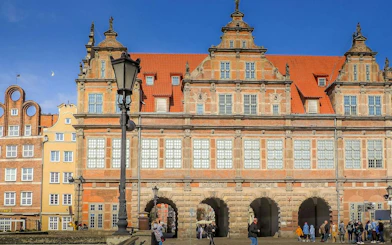 Gdansk Old Town building with red roof and arched entrances on self-guided audio tour.