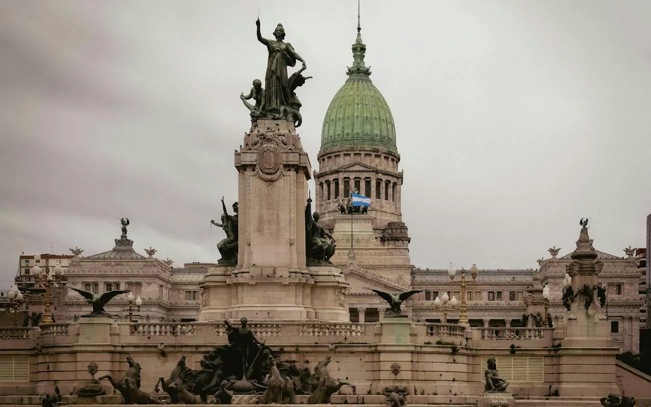Monument at Plaza de Mayo with Argentine flag and National Congress building, Buenos Aires.