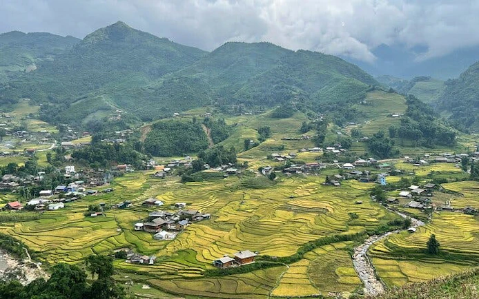Sapa rice terraces and village with mountains in the background, Vietnam trekking tour.
