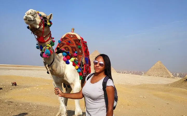 Camel ride near Giza Pyramids and Sphinx with tourist, Egypt.