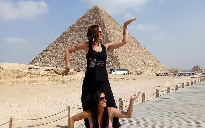 Tourists posing playfully in front of the Giza Pyramid, Egypt.
