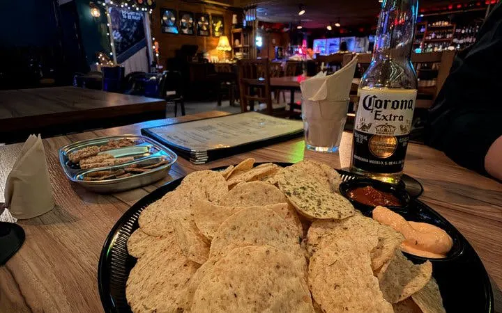 Seoul bar table with beer, chips, and dip during Chimaek night food experience.