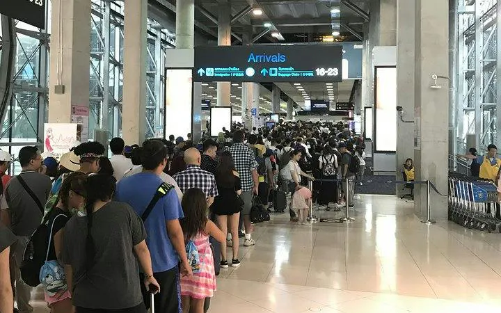 Phuket Airport arrivals area with long queue for immigration services.