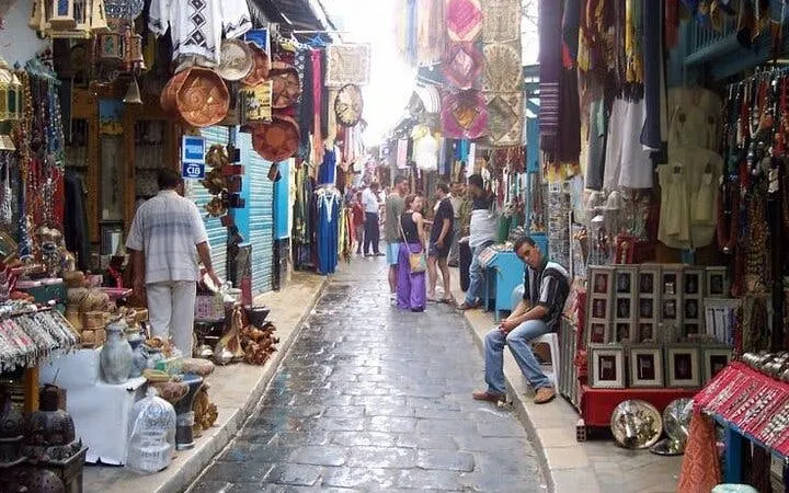 Market street in Casablanca with colorful textiles and pottery, part of Marrakesh full-day excursion.