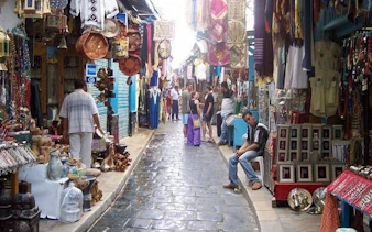 Market street in Casablanca with colorful textiles and pottery, part of Marrakesh full-day excursion.