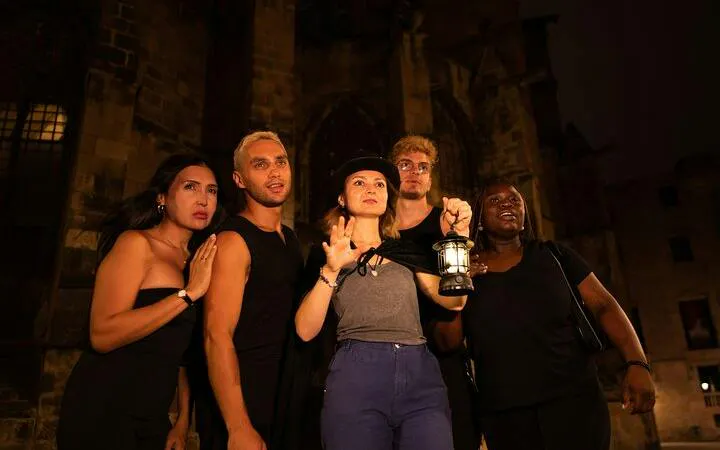 Group on a ghost walking tour in Barcelona's Gothic Quarter at night.