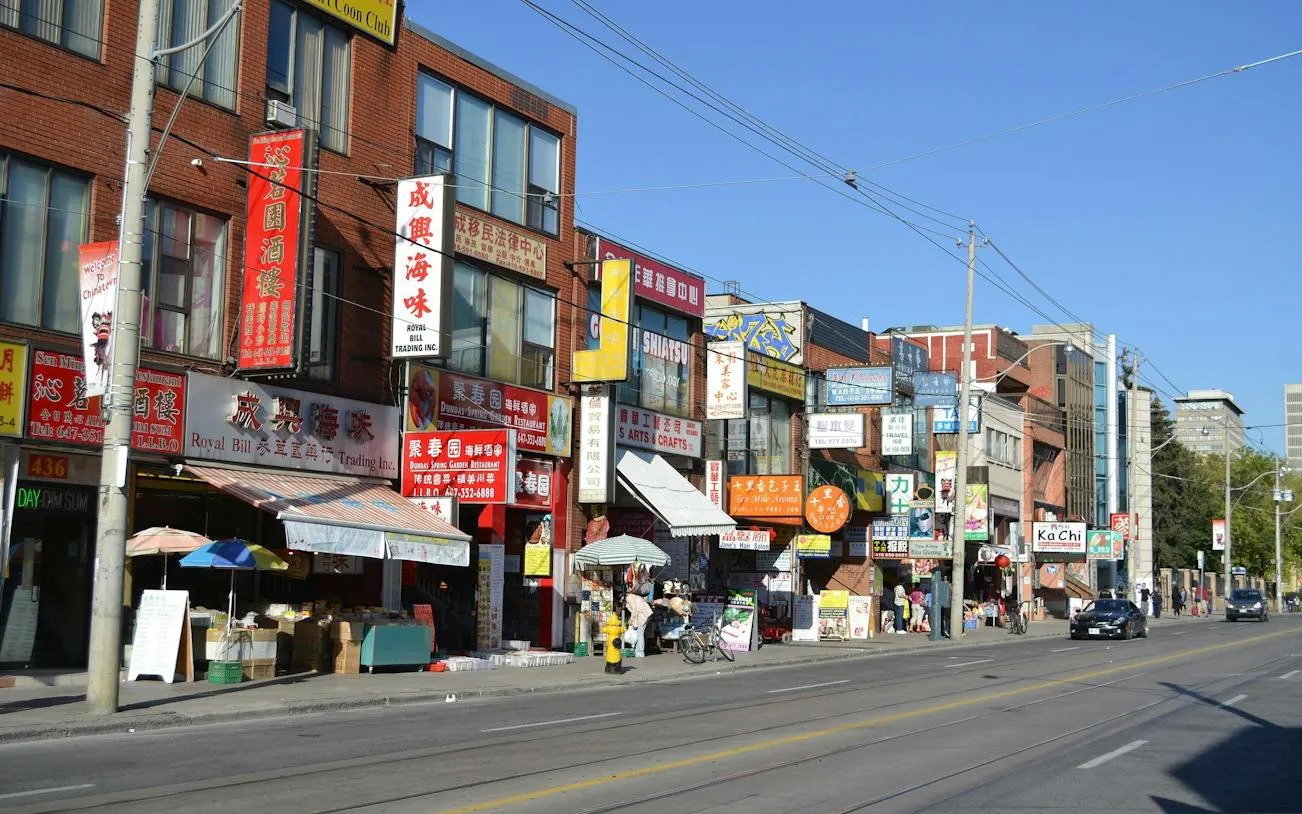 Shops and signs in Toronto's Chinatown along Spadina Avenue, part of a self-guided audio walk.