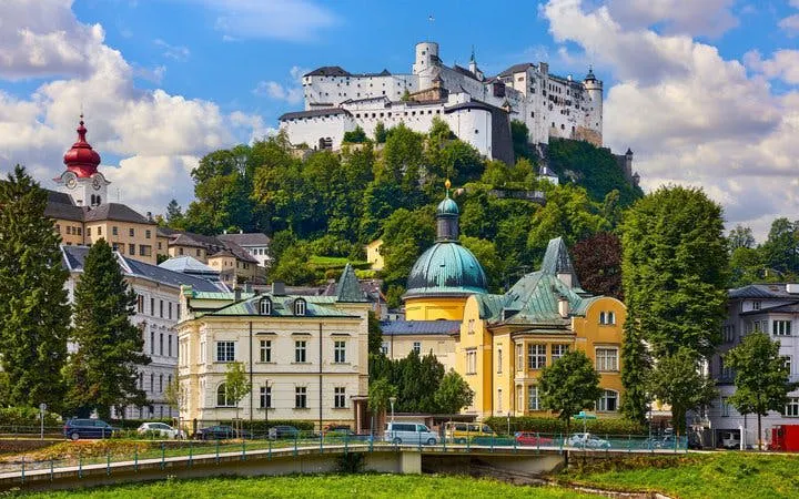 Salzburg cityscape with Hohensalzburg Fortress on a hill, viewed from a self-guided walking tour.