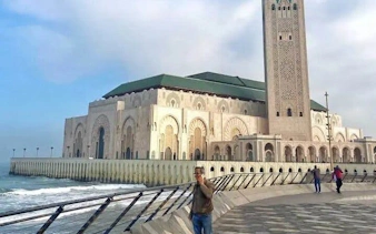 Hassan II Mosque exterior view, Casablanca, with oceanfront promenade.