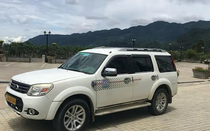Private car for Sapa to Ha Giang City transfer with mountain backdrop.