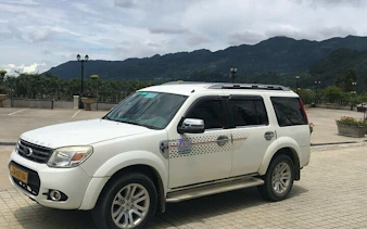 Private car for Sapa to Ha Giang City transfer with mountain backdrop.