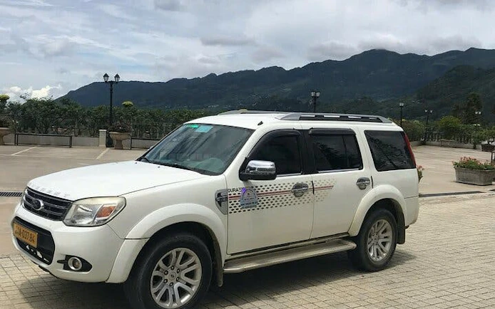 Private car for Sapa to Ha Giang City transfer with mountain backdrop.