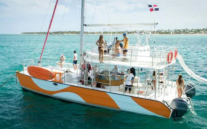 Catamaran with tourists enjoying open bar and snacks during Miches snorkeling cruise, Punta Cana.