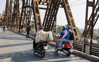 Vespas crossing Long Bien Bridge in Hanoi during countryside tour to Bat Trang Ceramic Village.