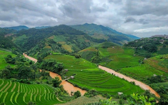 Terraced rice fields in Mu Cang Chai, Vietnam, with winding river and mountains in the background.
