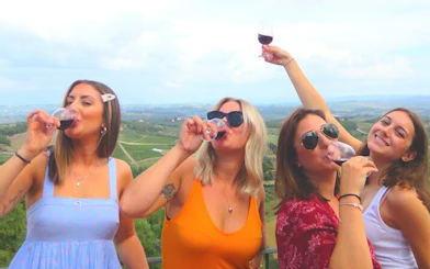 Tourists enjoying wine tasting at a Chianti winery with scenic vineyard views.