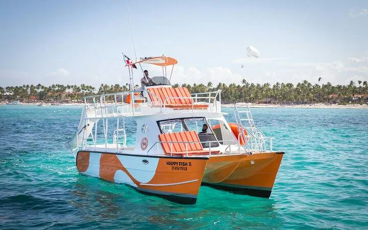 Catamaran cruising in Punta Cana's turquoise waters with beach in background.