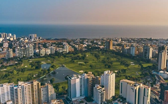 Aerial view of Lima cityscape with coastline and park, featured in self-guided walking tour app.