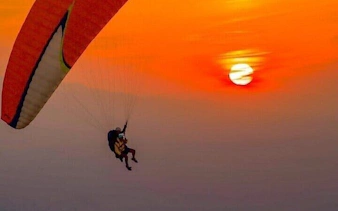Paragliding at sunset over Atlas Mountains and Lake, Marrakesh.