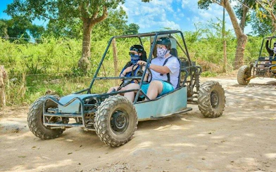 Tourists driving a buggy on a dirt path during the Punta Cana Jungle Buggy Guided Tour.