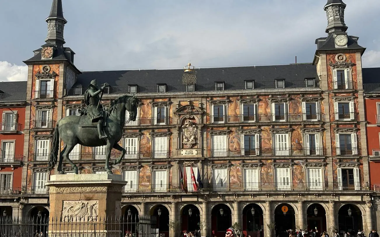 Plaza Mayor statue and historic building in Madrid's city center.