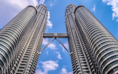 Petronas Twin Towers in Kuala Lumpur against a blue sky.