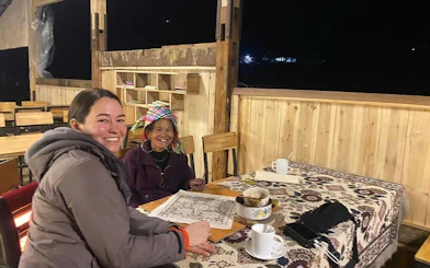 Batik painting session with Hmong artisans at a table in Ta Van workshop.