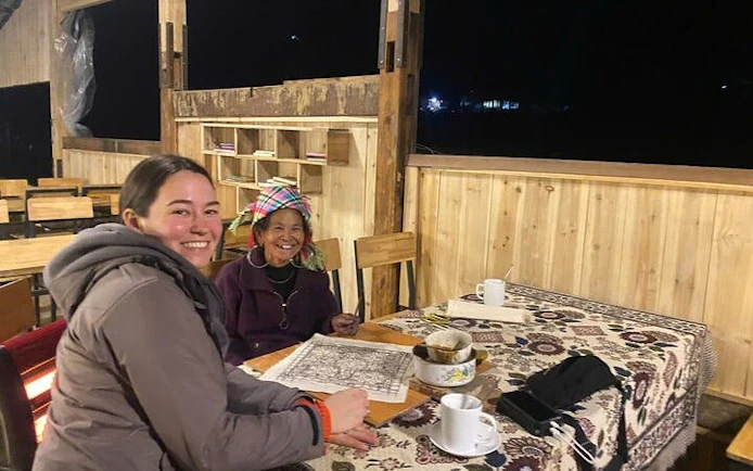 Batik painting session with Hmong artisans at a table in Ta Van workshop.
