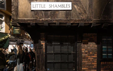 Little Shambles street in York with tourists exploring historic buildings.