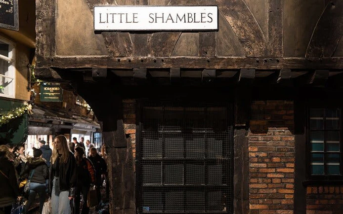 Little Shambles street in York with tourists exploring historic buildings.