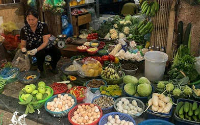 Hanoi street market vendor with fresh produce and eggs, part of Hanoi Highlights Vespa Tour.