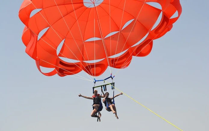 Parasailing over the Red Sea with a bright parachute, Hurghada adventure.