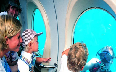 Family observing diver through submarine window on Tenerife tour.