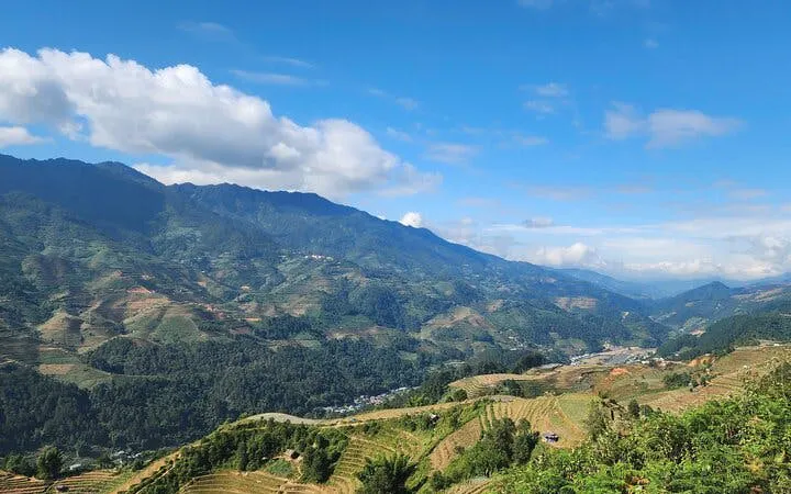 Rice terraces and mountains in Sapa, Vietnam under a clear blue sky.