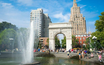Washington Square Park arch and fountain in Manhattan, New York City, with people exploring.