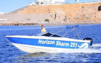 Private speedboat on Sharm El Sheikh coast with cliffs in background.